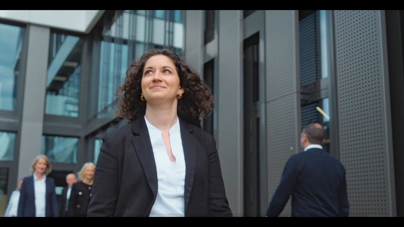 DZ HYP Employer Branding Film Eine Frau geht an einem Gebäude vorbei und blickt nach oben